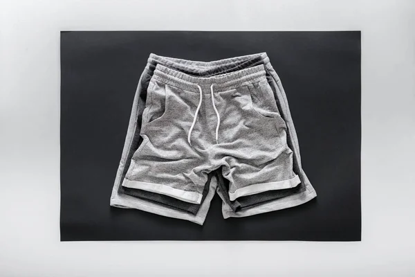 Crumpled gray black shorts pants for man sport. Set Various of Basic casual clothing sports gray male shorts On white black frame background. Minimalistic basic clothing concept. Top View — Stock Photo, Image