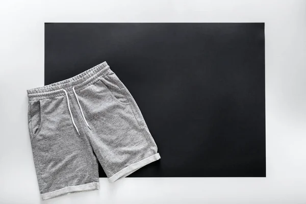 Gray shorts pants for man sport. Basic casual clothing sports gray male shorts On white black frame background with copy space. Minimalistic basic clothing concept. Top View — Stock Photo, Image