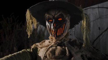 Parlak ağızlı ve şapkalı korkunç bir korkuluk. Korkunç Cadılar Bayramı kostümü.