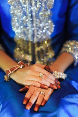 Gelinin el ile elmas yüzük, mavi bir gelinlik giyiyor