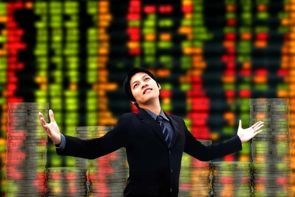 Happy smiling young businessman wearing black suit concept of success,Working successful, leadership and victory in business. blur background display of Stock market quotes