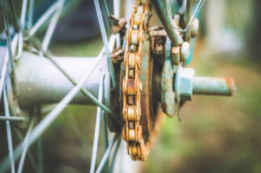 Close up of old rusty chain from the bicycle on background nature ,Bicycle's detail view of wheel with old chain, sprocket,dirty chain (Vintage tone) 