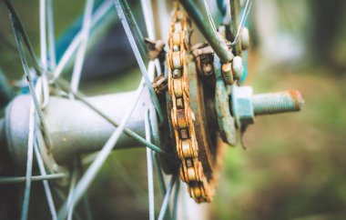 Close up of old rusty chain from the bicycle on background nature ,Bicycle's detail view of wheel with old chain, sprocket,dirty chain (Vintage tone) 