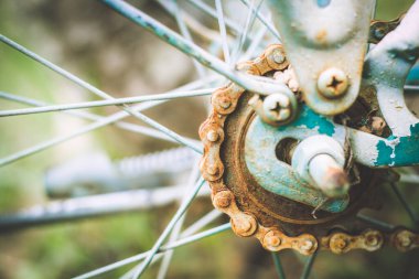 Close up of old rusty chain from the bicycle on background nature ,Bicycle's detail view of wheel with old chain, sprocket,dirty chain (Vintage tone) 