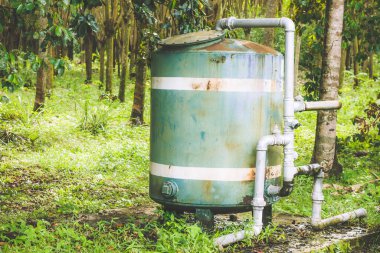 A close up of a rusted valve connects to water supply with metal pipe,Industrial metal water tab,seen in a garden, for watering the plants