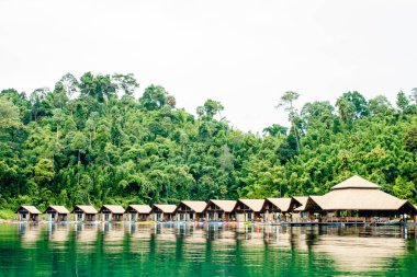 Sai yok, Kanchanaburi, Tayland 'da Kwai nehrinde yüzen tahta bir sal ve dağ sisi.