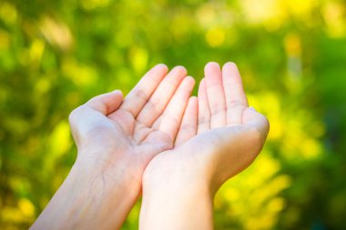 Boş kadın eli yeşil bokeh arka planda..