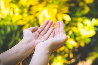 Boş kadın eli yeşil bokeh arka planda..