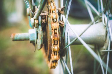 Close up of old rusty chain from the bicycle on background nature ,Bicycle's detail view of wheel with old chain, sprocket,dirty chain (Vintage tone) 