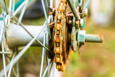 Close up of old rusty chain from the bicycle on background nature ,Bicycle's detail view of wheel with old chain, sprocket,dirty chain (Vintage tone) 