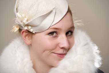 Kızıl saçlı beyaz keçe şapka ve kürk yüzsüzce gülümseyen
