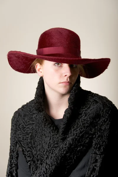 Redhead serious in maroon hat and black coat — Stock Photo, Image
