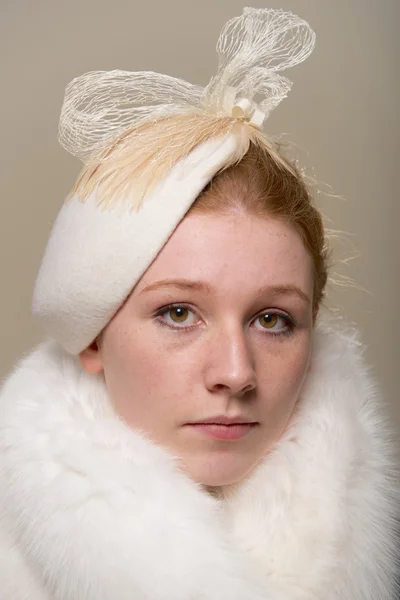 Redhead serious in white hat with bow and fur — Stock Photo, Image