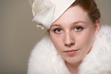 Kızıl saçlı beyaz bir ciddi keçe şapka ve kürk