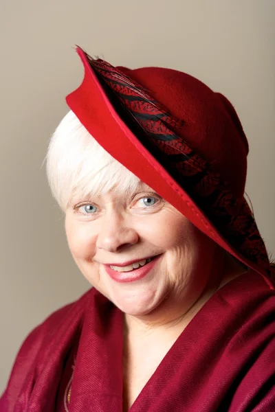 White-haired woman in red hat and shawl — Stock Photo, Image