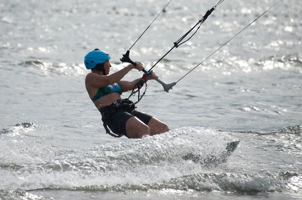 Backlit vrouwelijke kite surfer in blauwe helm — Stockfoto