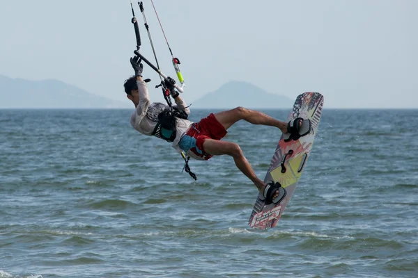 Kite surfer jumping with arm hiding face — Stock Photo, Image