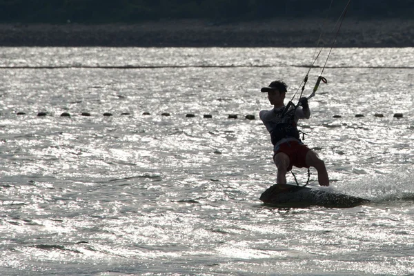 Cerf-volant masculin silhouette contre les vagues brillantes — Photo