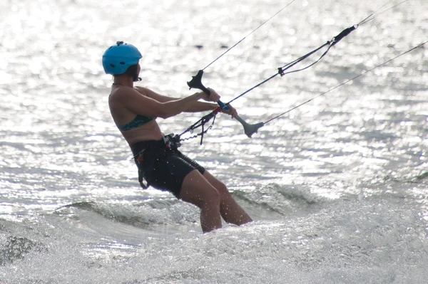 Kite surfař v helma podsvícení proti vlny — Stock fotografie