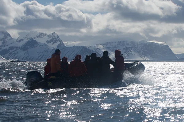 Equipa do Zodíaco retroiluminada a passar pelas montanhas do Árctico — Fotografia de Stock