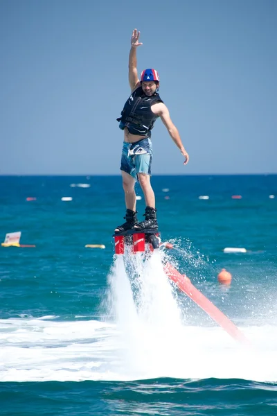 Flyboarder lanzando el brazo por encima de su cabeza —  Fotos de Stock