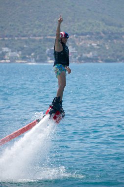 Flyboarder siyah yeleği gökyüzü için işaret içinde