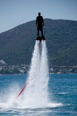 Flyboarder karşı ağaçlık yamaca kontrast siyah