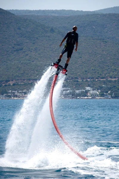 Flyboarder em preto inclinado para a frente em mergulho — Fotografia de Stock