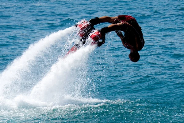 Flyboarder em mergulho vermelho headfirst na água — Fotografia de Stock