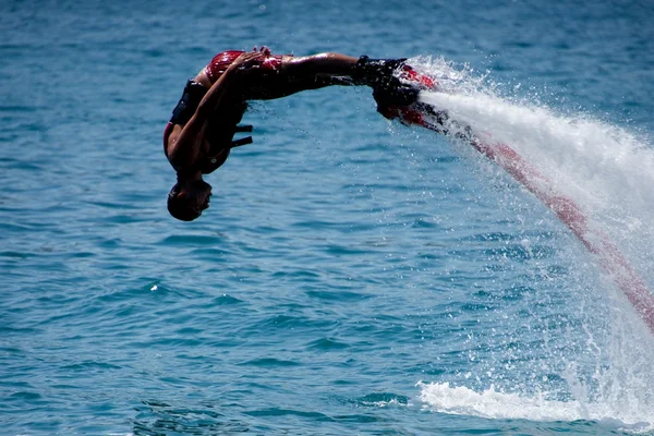 Flyboarder en rojo propulsado por chorro de agua —  Fotos de Stock