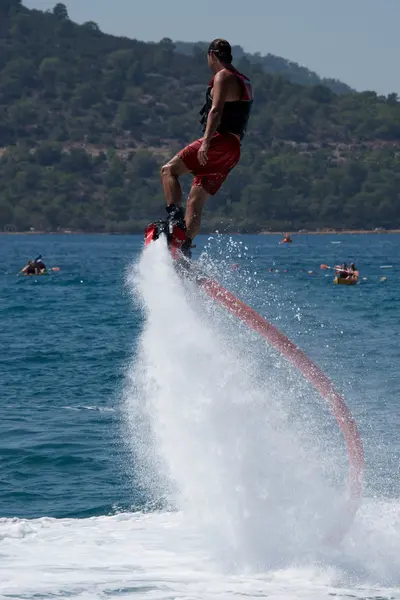Flyboarder girando en el aire cerca de los kayaks —  Fotos de Stock