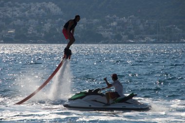 Adam Jet Ski üzerinde yukarıda crouching Flyboarder