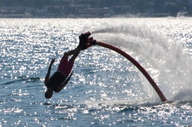 Geriye doğru tekniklerle arkadan aydınlatmalı denize dalış Flyboarder