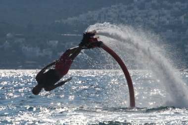 Çapraz tekniklerle arkadan aydınlatmalı dalgaları içine dalış Flyboarder