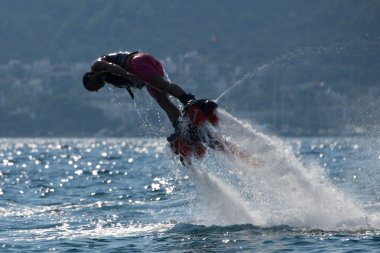 Flyboarder sola doğru dalış pembe şortlu