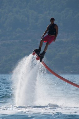 Flyboarder sağa dönerek pembe şortlu