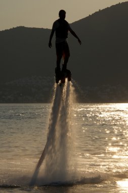 Ormanlık tepeler yanında gün batımında yukarıdan Flyboarder