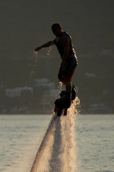 Close-up de silhueta Flyboarder gotejamento com água — Fotografia de Stock