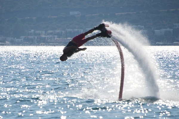 Flyboarder дайвінг headfirst залишаючи дуги спрей — стокове фото