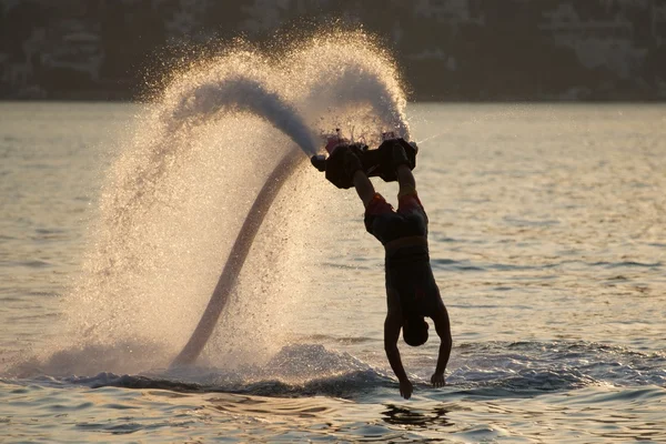 Flyboarder mergulho verticalmente com os braços esticados — Fotografia de Stock