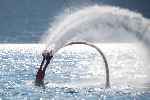 Flyboarder caindo para trás em ondas retroiluminadas — Fotografia de Stock