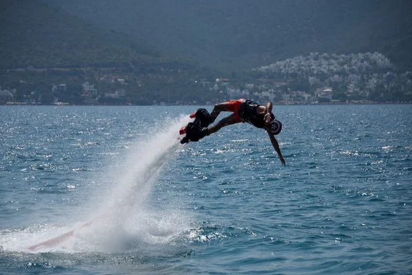 Flyboarder em capacete mergulho horizontal no mar — Fotografia de Stock