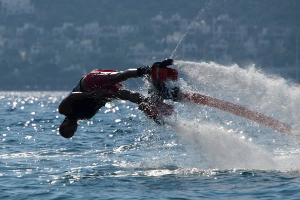 Flyboarder em mergulho baixo em ondas retroiluminadas — Fotografia de Stock