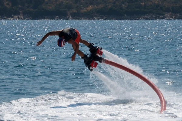Flyboarder em shorts rosa mergulho em água branca — Fotografia de Stock