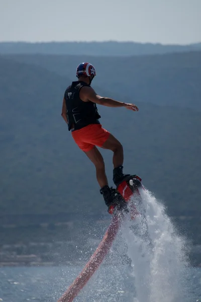 Flyboarder en pantalones cortos rosados haciendo giro en espiral —  Fotos de Stock