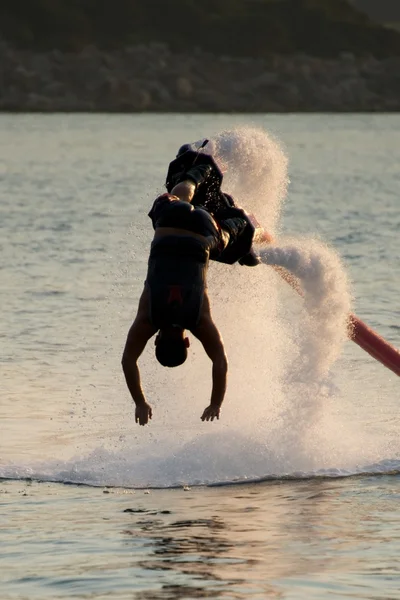 Flyboarder en silhouette plongeant verticalement en eau vive — Photo