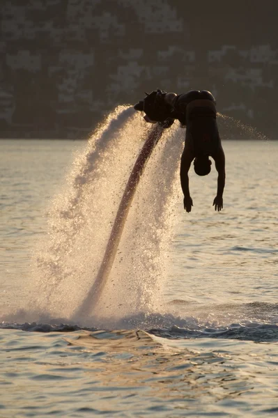 Flyboarder silueta en buceo hacia el mar de la tarde —  Fotos de Stock
