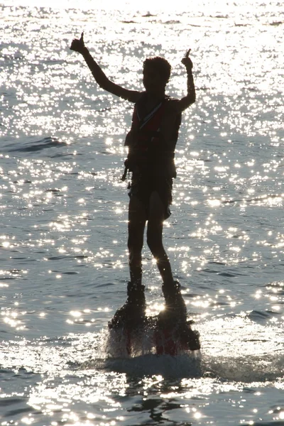 Flyboarder silhueta dando polegares para cima com ambas as mãos — Fotografia de Stock