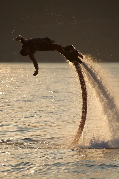 Flyboarder spray trailing extiende los brazos hacia el agua —  Fotos de Stock