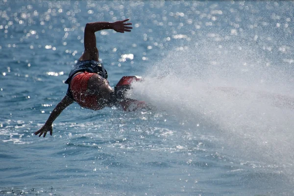 Flyboarder con los brazos extendidos bajos sobre el agua —  Fotos de Stock